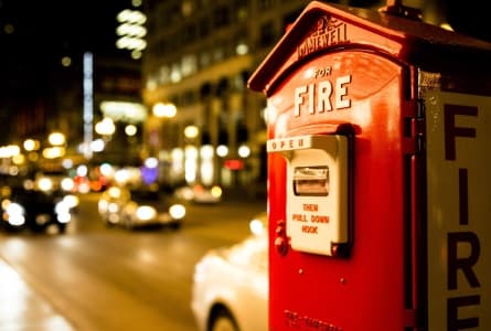 Classic red fire alarm call box on a city street — Sujay Fire LLP, fire safety and protection in Pune, Maharashtra